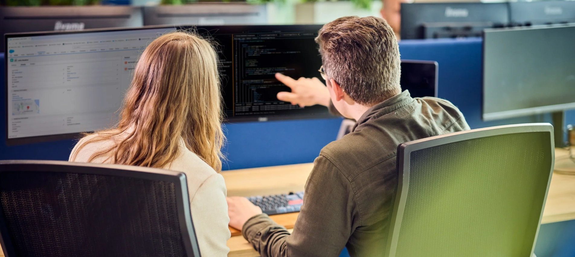 IT partner wijst iets aan op een beeldscherm